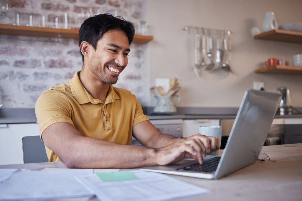 Man, work from home or search internet on laptop with paperwork and sticky note in his kitchen. Asi